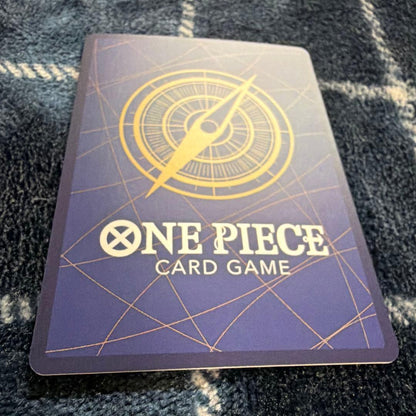 Used One Piece Card Game Nami R OP06-101 promotional card showing minor scratches and stored in protective sleeve