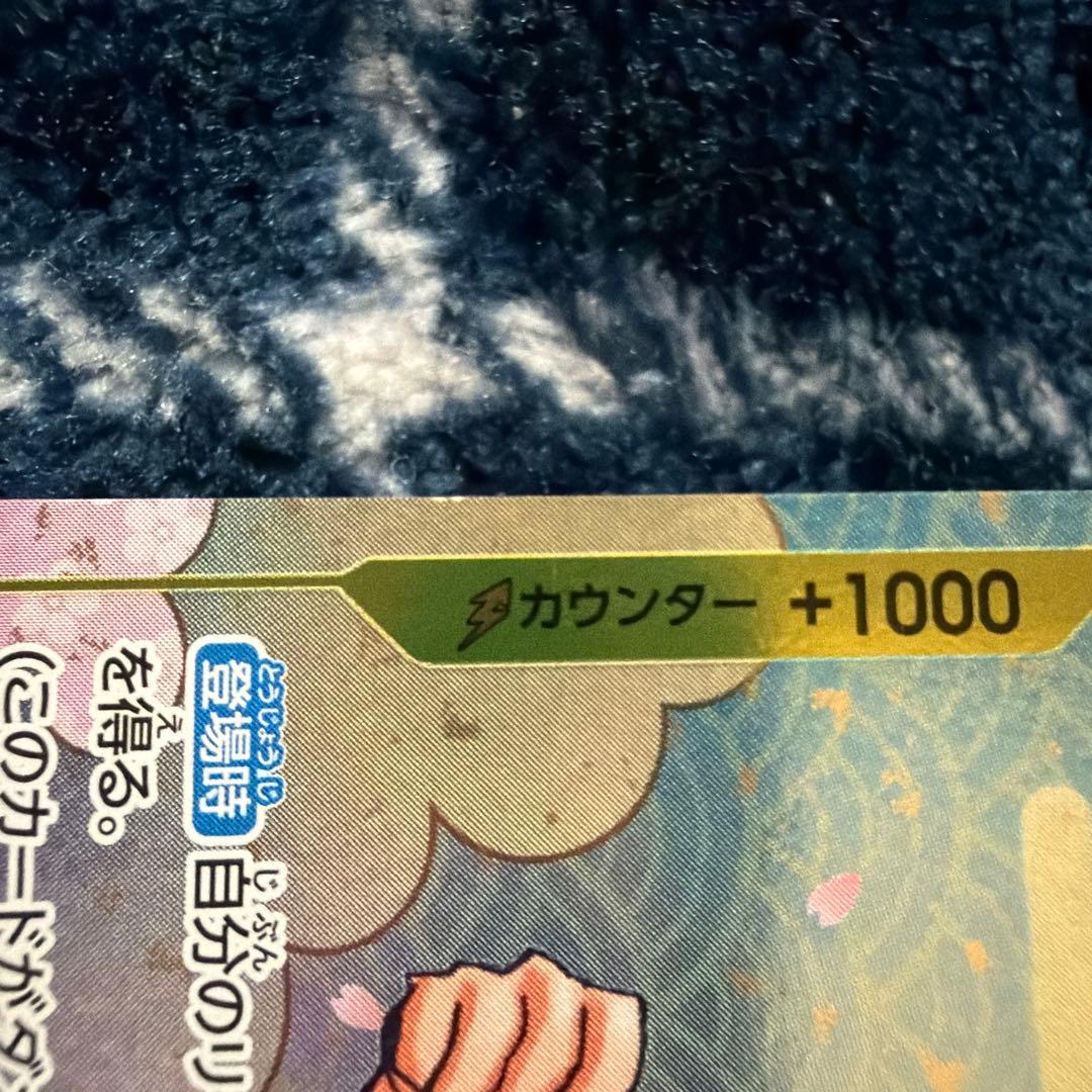 Used One Piece Card Game Nami R OP06-101 promotional card showing minor scratches and stored in protective sleeve