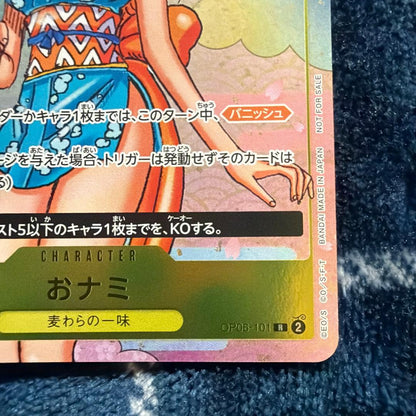 Used One Piece Card Game Nami R OP06-101 promotional card showing minor scratches and stored in protective sleeve