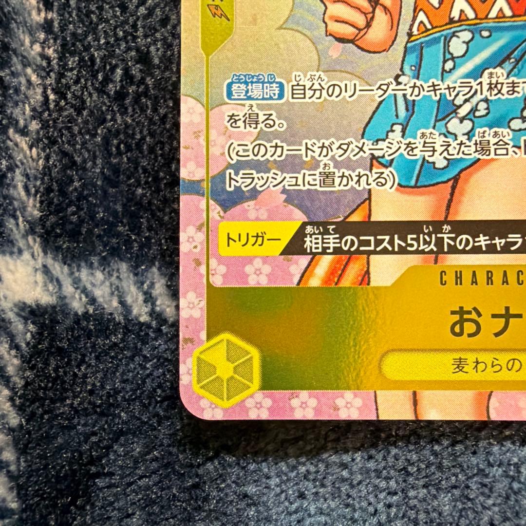 Used One Piece Card Game Nami R OP06-101 promotional card showing minor scratches and stored in protective sleeve
