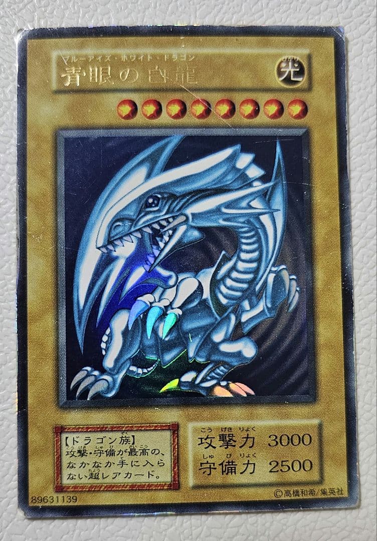 Yugioh Blue-Eyes White Dragon Ultra Rare card from 1999 Starter Box showing scratches and edge wear