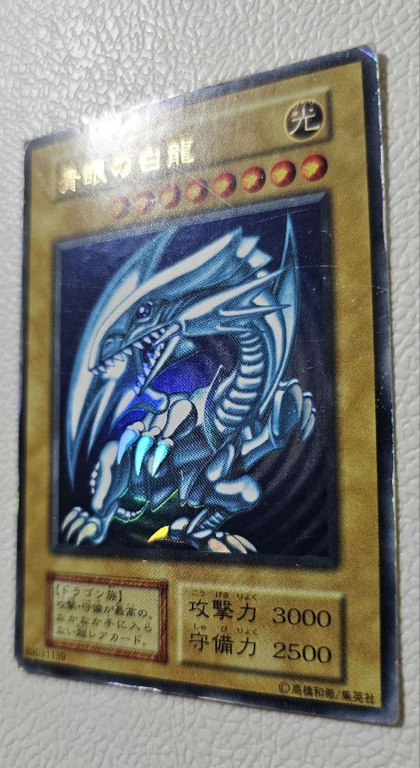 Yugioh Blue-Eyes White Dragon Ultra Rare card from 1999 Starter Box showing scratches and edge wear