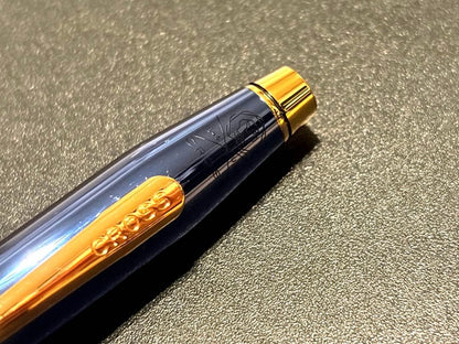 Cross Century II ballpoint pen with navy blue body and gold accents on a white background