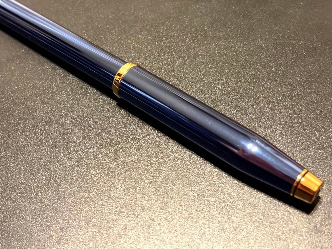 Cross Century II ballpoint pen with navy blue body and gold accents on a white background
