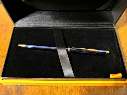 Cross Century II ballpoint pen with navy blue body and gold accents on a white background