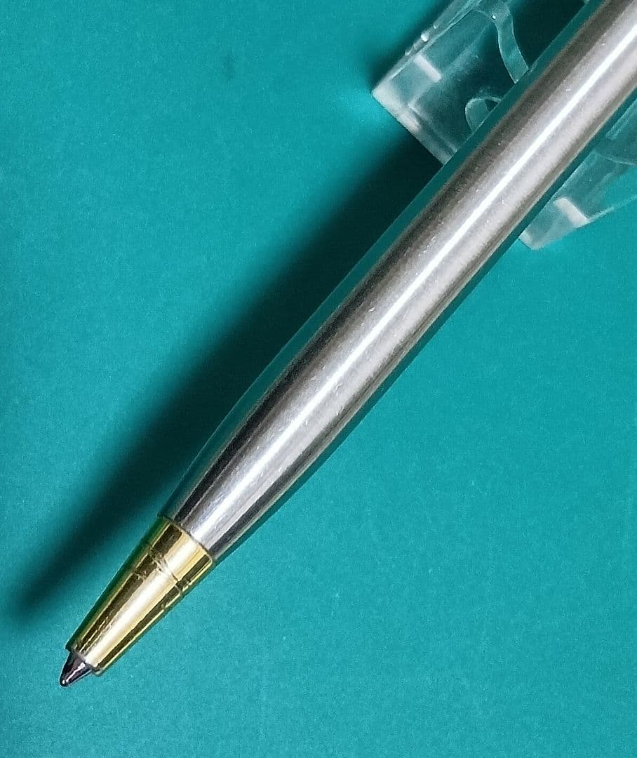 Used Unknown Brand twist ballpoint pen with silver and gold two-tone metal body and red CROSS refill