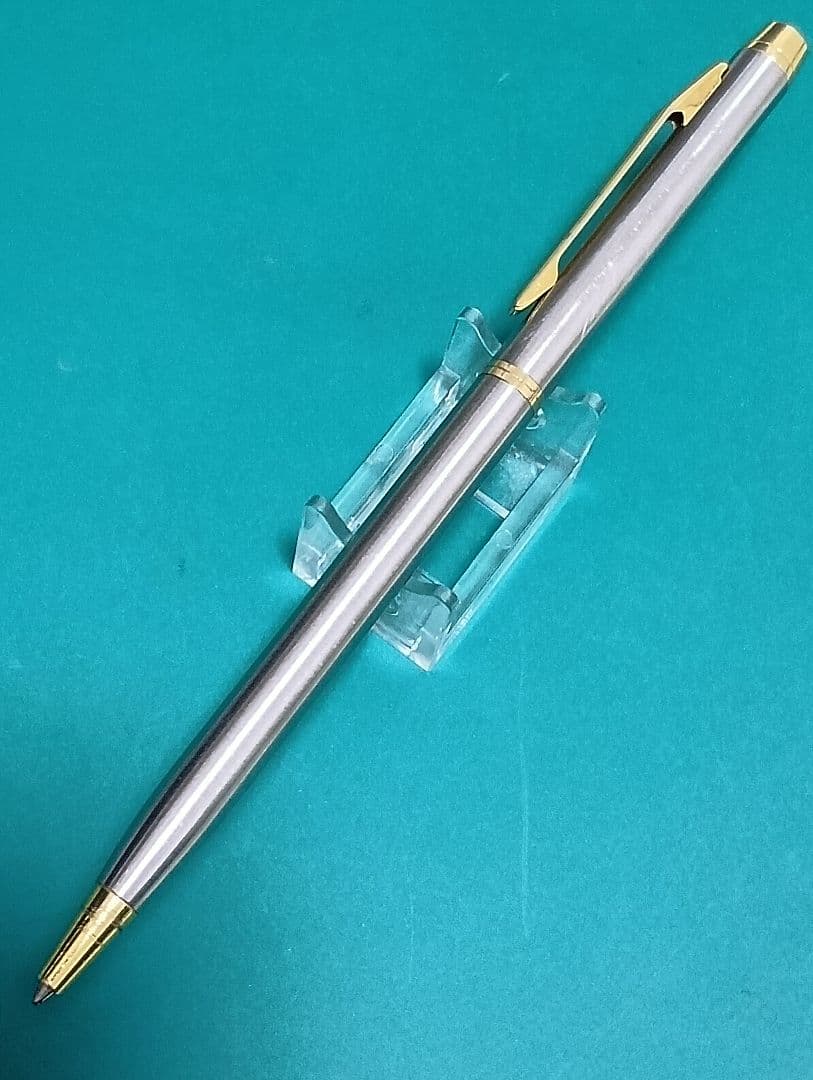 Used Unknown Brand twist ballpoint pen with silver and gold two-tone metal body and red CROSS refill