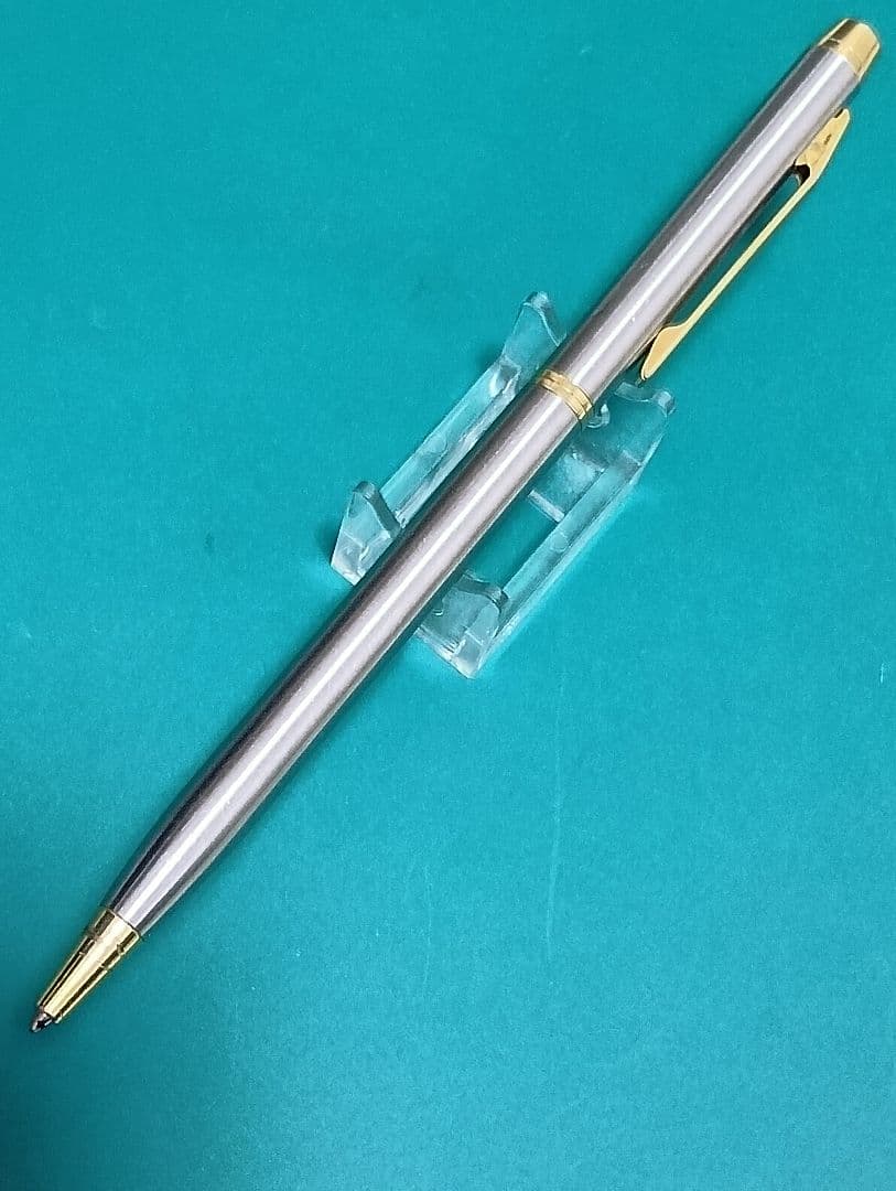 Used Unknown Brand twist ballpoint pen with silver and gold two-tone metal body and red CROSS refill