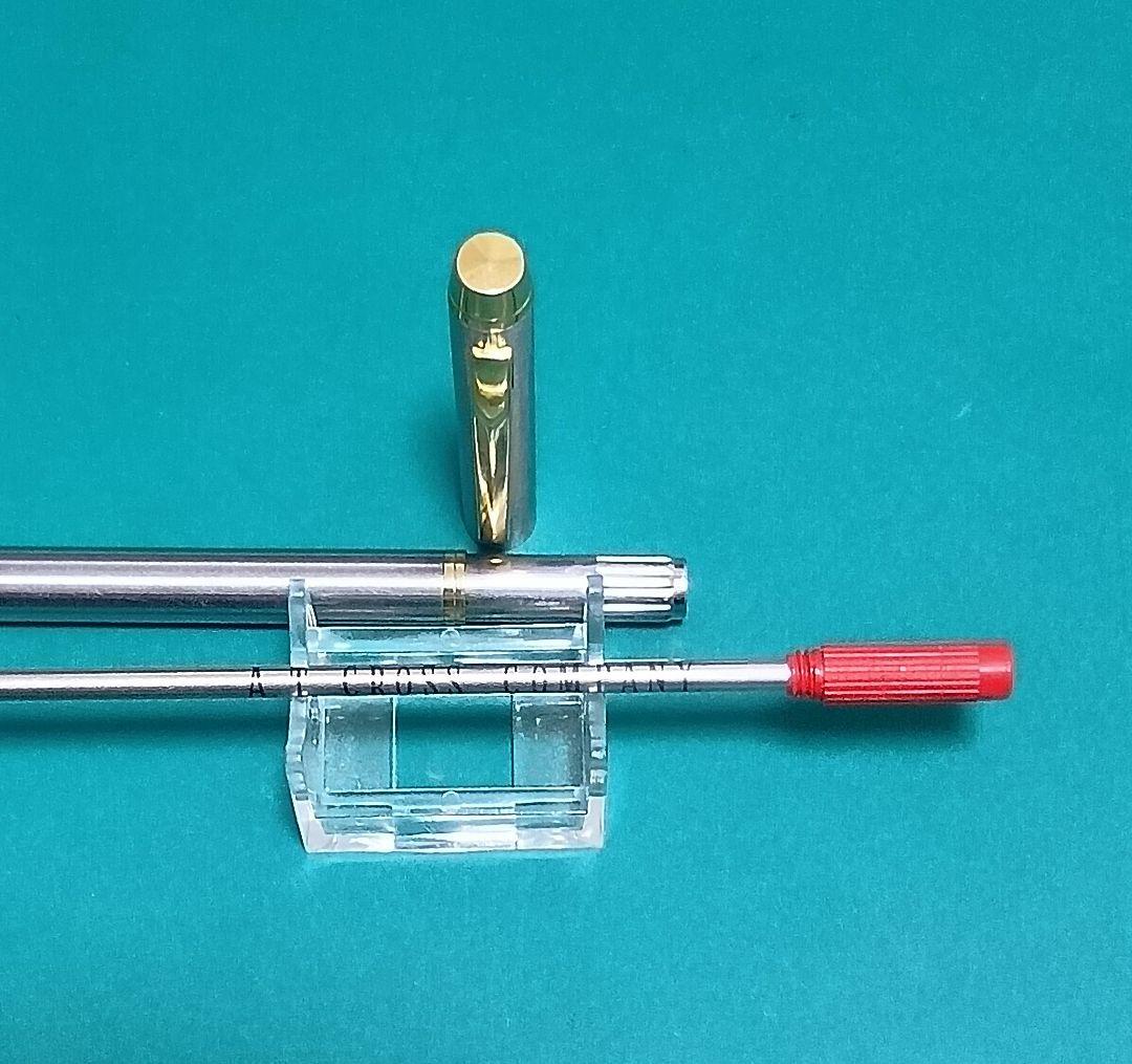 Used Unknown Brand twist ballpoint pen with silver and gold two-tone metal body and red CROSS refill