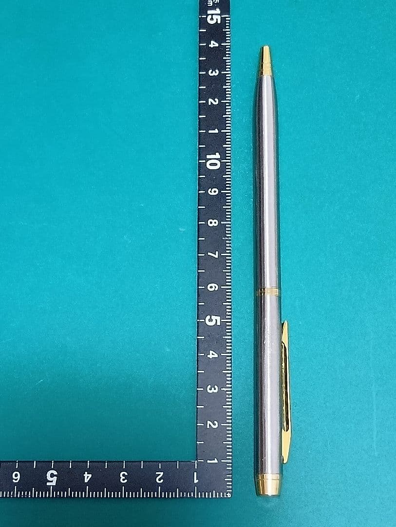 Used Unknown Brand twist ballpoint pen with silver and gold two-tone metal body and red CROSS refill