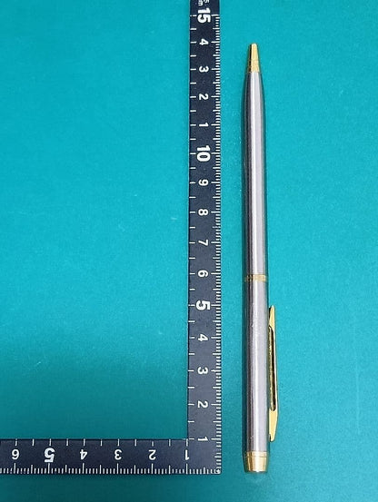 Used Unknown Brand twist ballpoint pen with silver and gold two-tone metal body and red CROSS refill