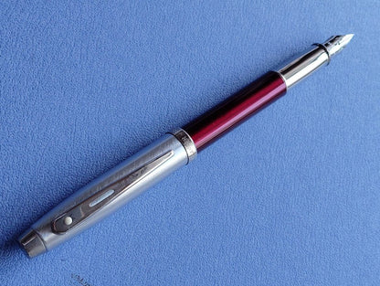 Sheaffer 100 Year fountain pen with red body, silver hairline stainless steel cap, white dot clip, and F nib