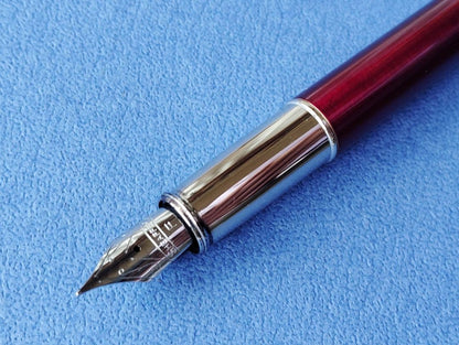 Sheaffer 100 Year fountain pen with red body, silver hairline stainless steel cap, white dot clip, and F nib