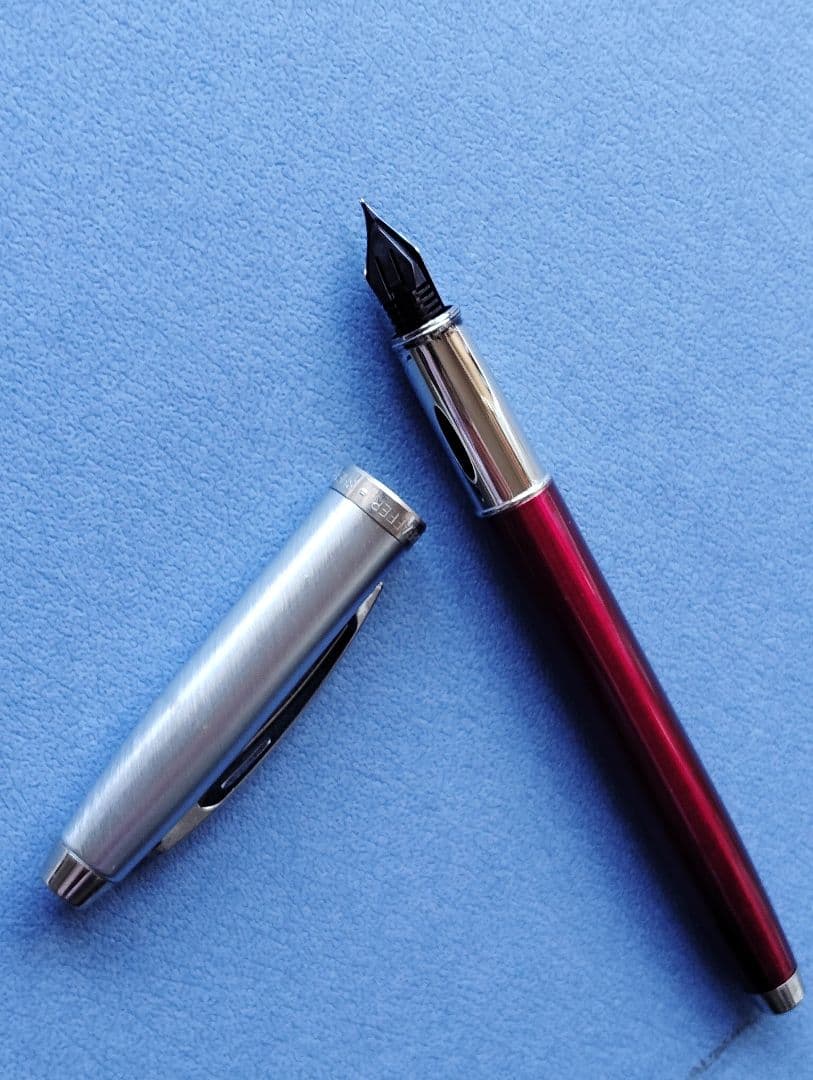 Sheaffer 100 Year fountain pen with red body, silver hairline stainless steel cap, white dot clip, and F nib