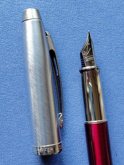 Sheaffer 100 Year fountain pen with red body, silver hairline stainless steel cap, white dot clip, and F nib