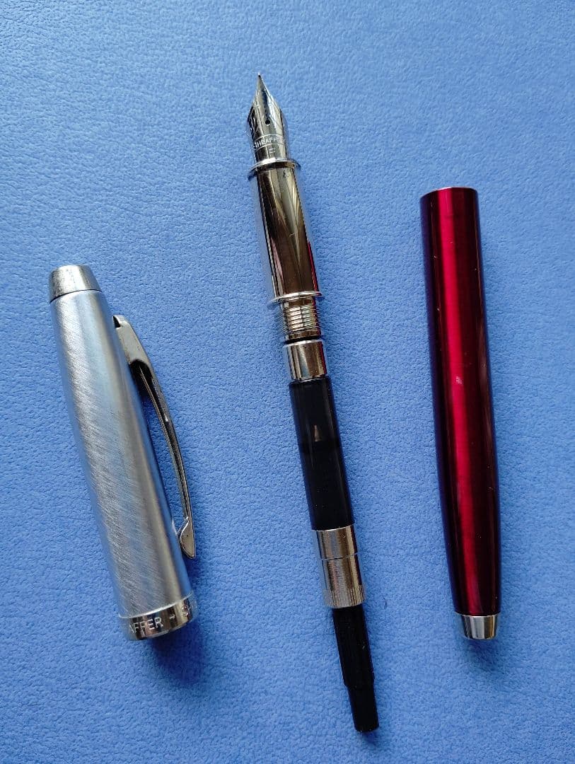 Sheaffer 100 Year fountain pen with red body, silver hairline stainless steel cap, white dot clip, and F nib
