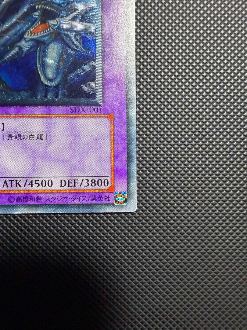 Blue-Eyes Ultimate Dragon Relief card SDX-001 from Japan with visible wear and white spots