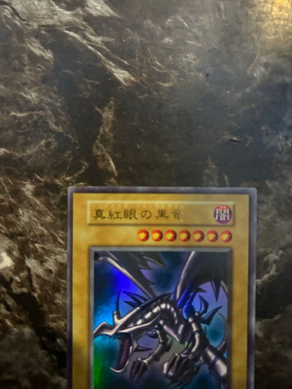 Yugi-Oh Early Ultra Rare Red Eyes Black Dragon playing card from OCG with minor wear and scratches