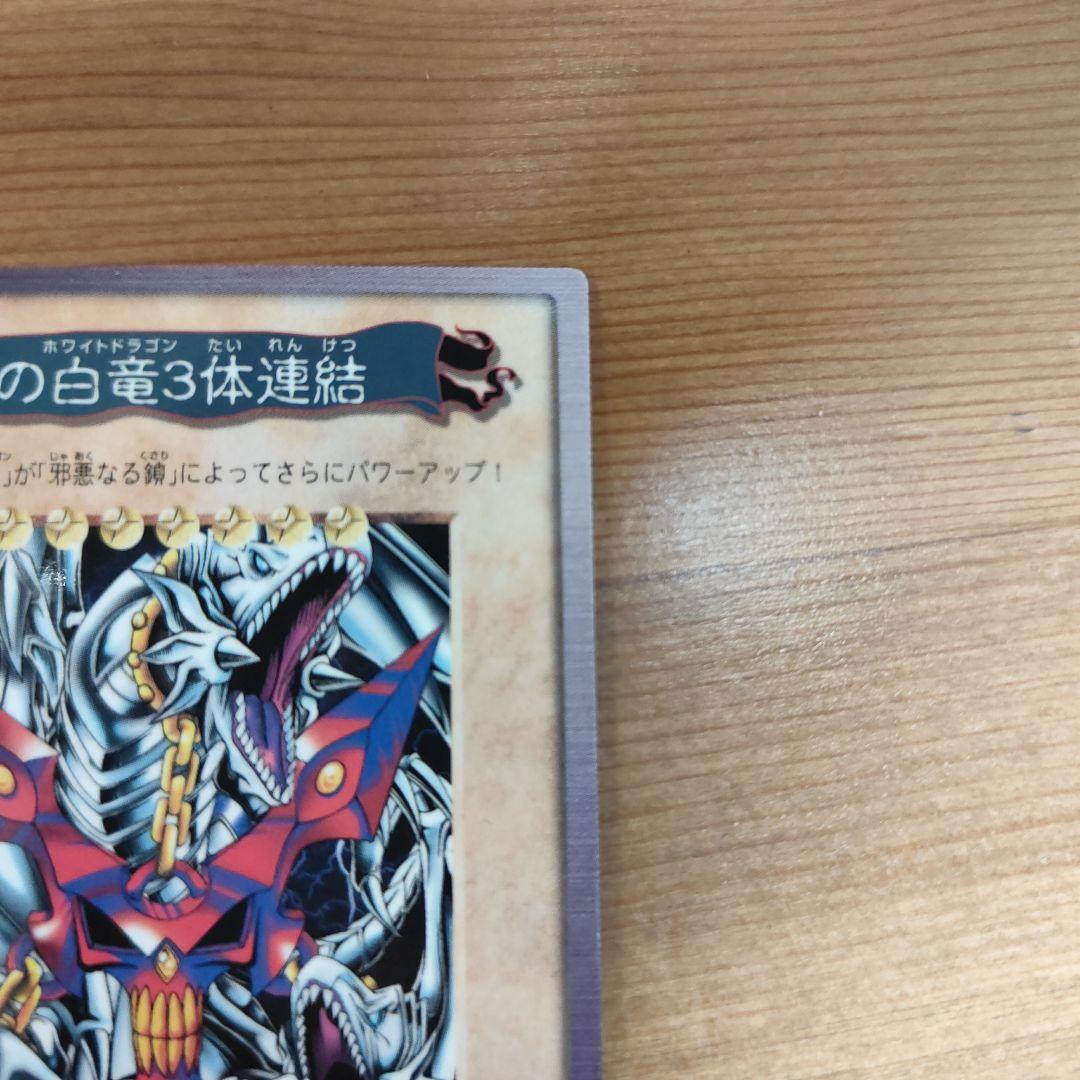 Bandai Yu-Gi-Oh! Blue-Eyes White Dragon three linked monster cards in storage sleeves showing minor wear