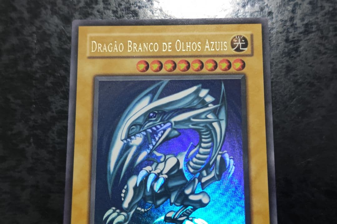 Portuguese Blue-Eyes White Dragon Ultra Rare Yu-Gi-Oh! card with minor scratches on front and back