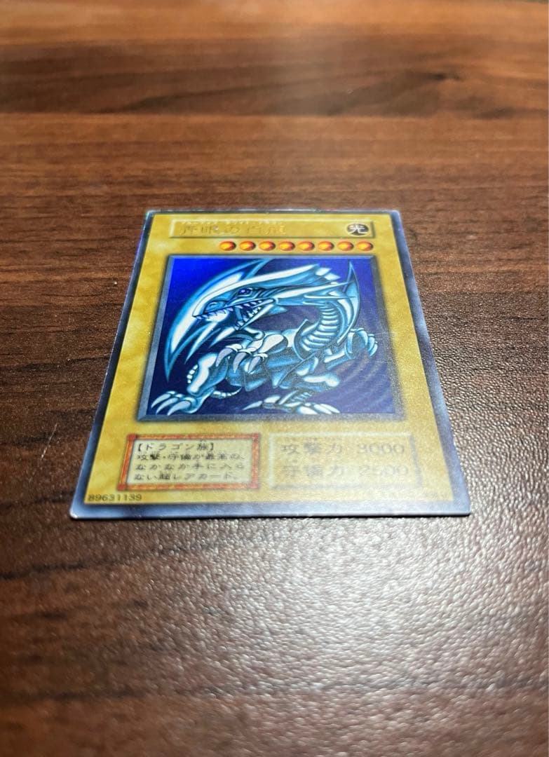Yu-Gi-Oh Blue-Eyes White Dragon Initial Ultra Rare card in screw-down case with metallic border and slight scratches