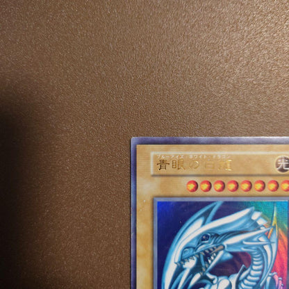 Yugioh Blue-Eyes White Dragon Ultra Rare Initial Edition monster card with minor border glitter and small scratches