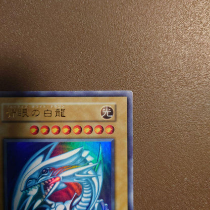 Yugioh Blue-Eyes White Dragon Ultra Rare Initial Edition monster card with minor border glitter and small scratches