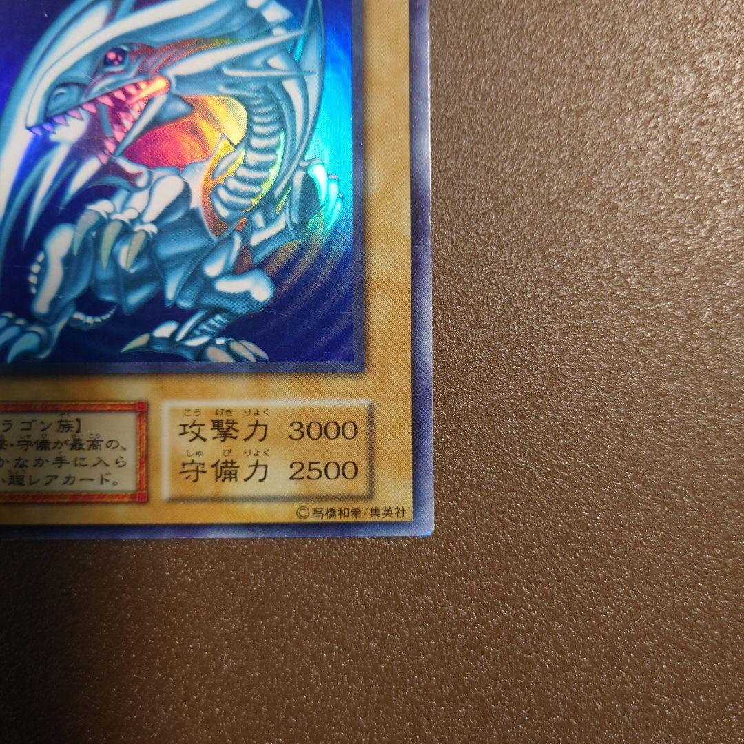 Yugioh Blue-Eyes White Dragon Ultra Rare Initial Edition monster card with minor border glitter and small scratches