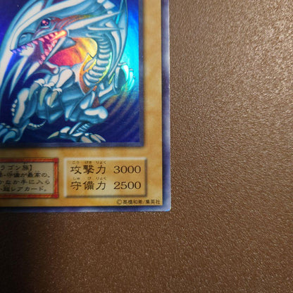 Yugioh Blue-Eyes White Dragon Ultra Rare Initial Edition monster card with minor border glitter and small scratches