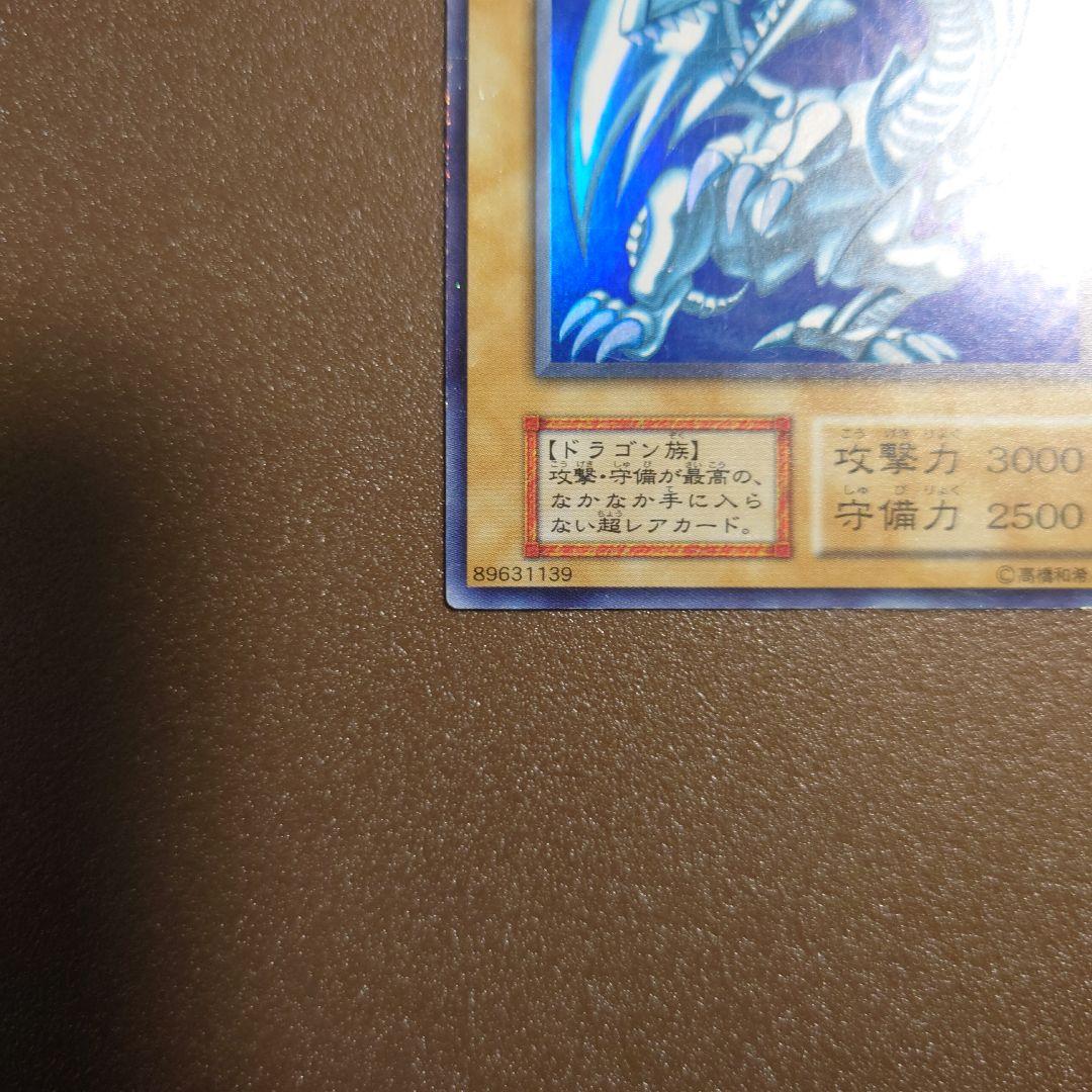 Yugioh Blue-Eyes White Dragon Ultra Rare Initial Edition monster card with minor border glitter and small scratches