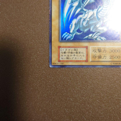 Yugioh Blue-Eyes White Dragon Ultra Rare Initial Edition monster card with minor border glitter and small scratches