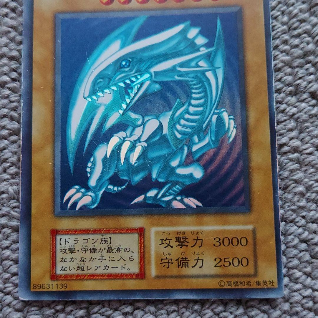 Bandai Yu-Gi-Oh Blue-Eyes White Dragon Ultra Rare Monster Card showing small scratches and frame misalignment