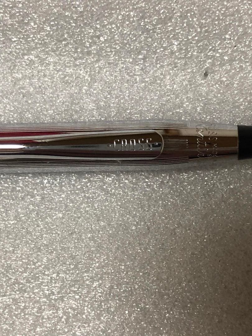 Cross brand sleek black pen with silver accents on a white background