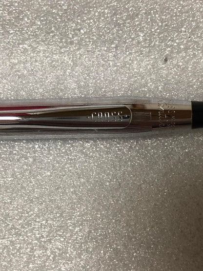 Cross brand sleek black pen with silver accents on a white background
