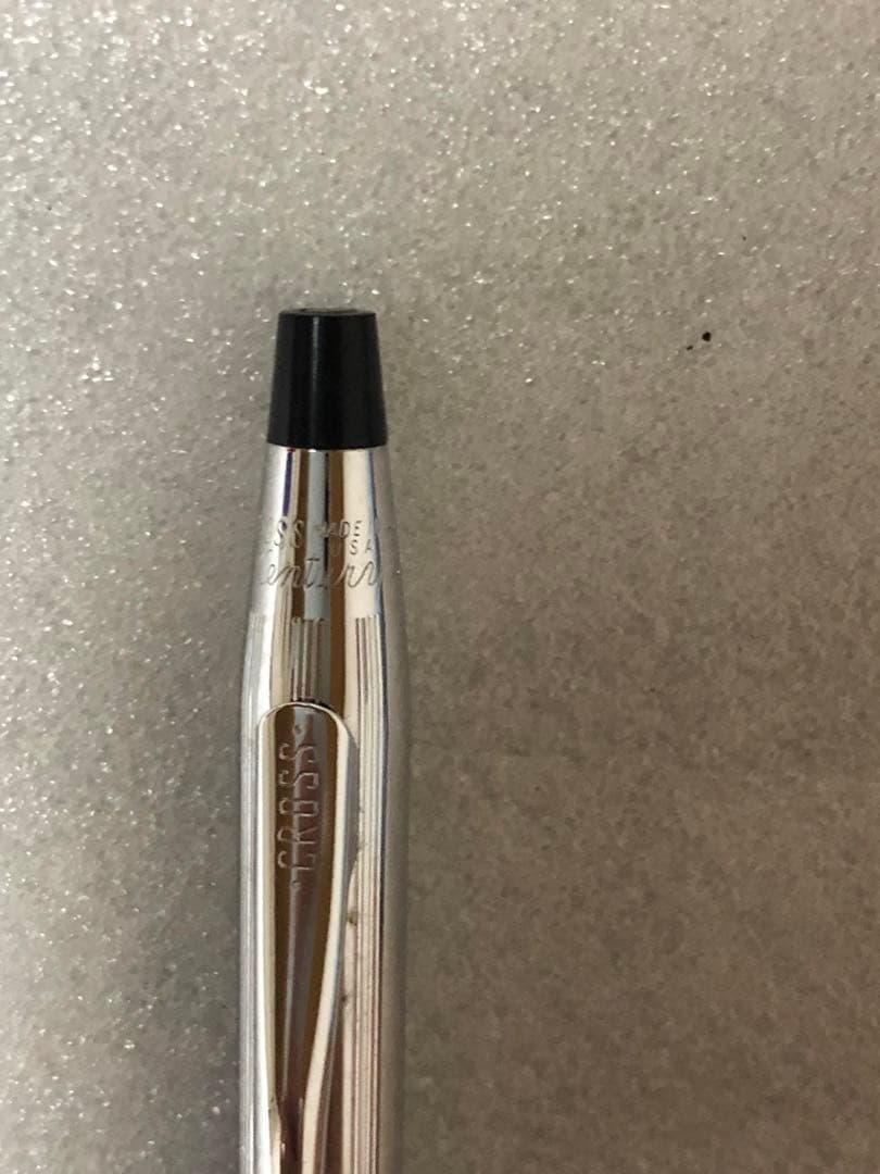 Cross brand sleek black pen with silver accents on a white background