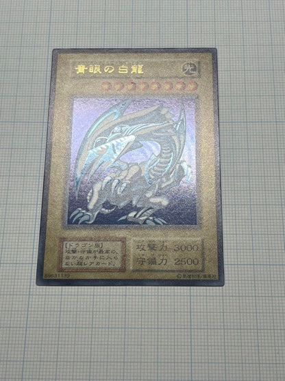 Yugioh Blue-Eyes White Dragon Ultra Rare trading card with light surface scratches and a small dent in the center
