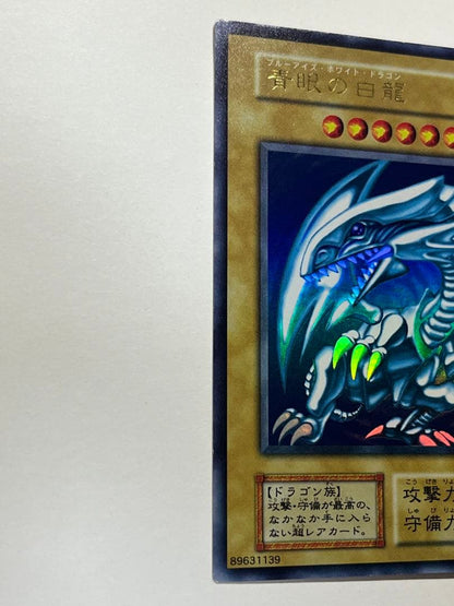 Yugioh Blue-Eyes White Dragon Ultra Rare trading card with light surface scratches and a small dent in the center