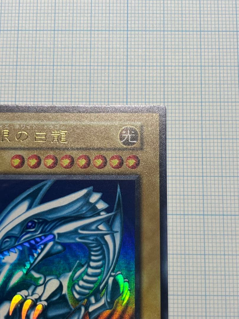 Yugioh Blue-Eyes White Dragon Ultra Rare trading card with light surface scratches and a small dent in the center