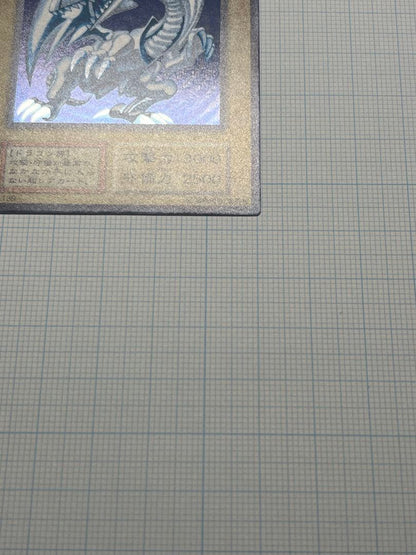 Yugioh Blue-Eyes White Dragon Ultra Rare trading card with light surface scratches and a small dent in the center