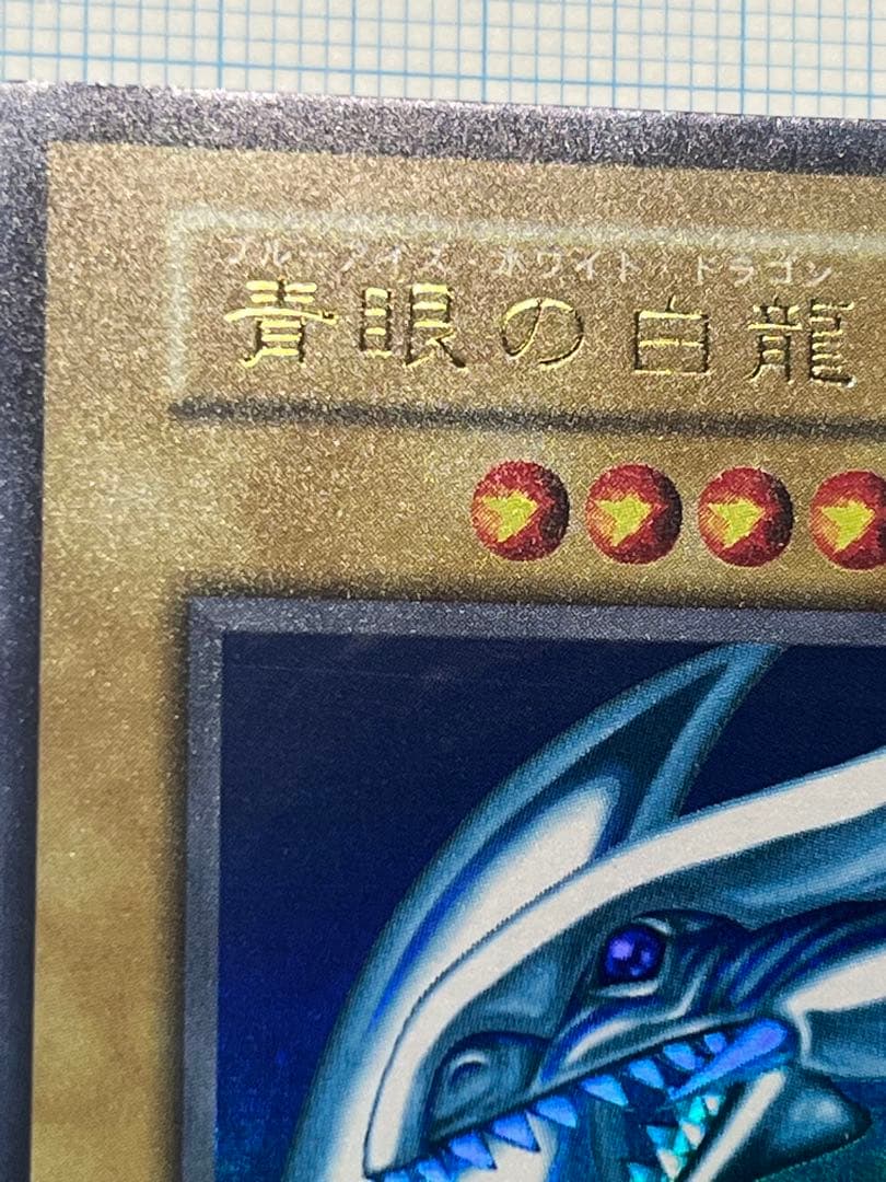 Yugioh Blue-Eyes White Dragon Ultra Rare trading card with light surface scratches and a small dent in the center