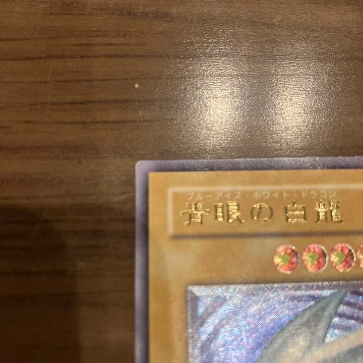 Blue-Eyes White Dragon Relief Card SM-51 with visible wear and a small white chip, Japanese Yu-Gi-Oh collectible