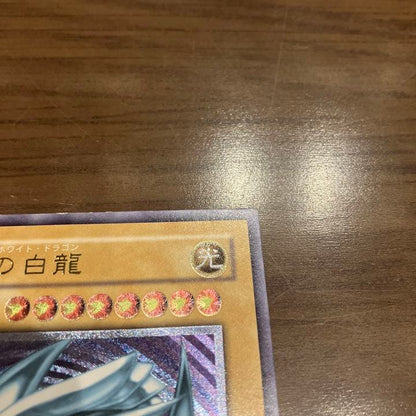 Blue-Eyes White Dragon Relief Card SM-51 with visible wear and a small white chip, Japanese Yu-Gi-Oh collectible