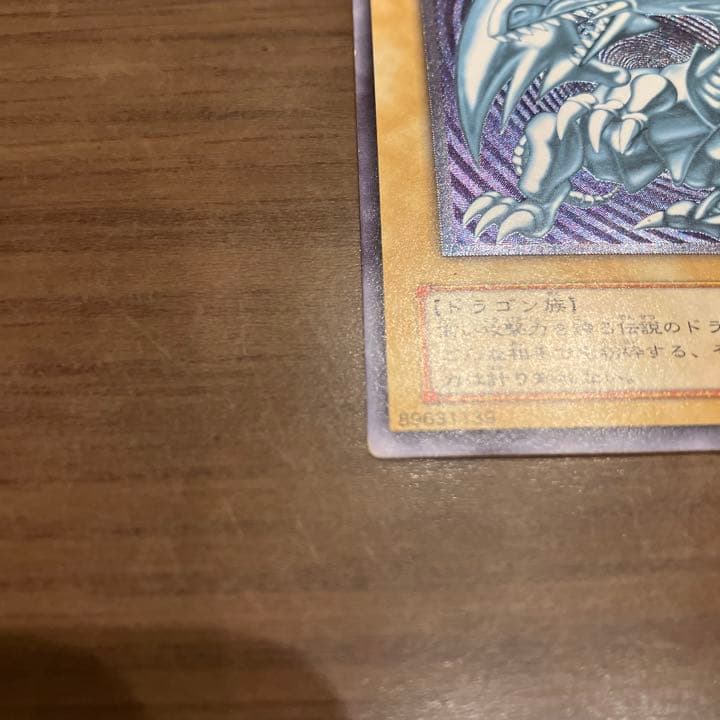 Blue-Eyes White Dragon Relief Card SM-51 with visible wear and a small white chip, Japanese Yu-Gi-Oh collectible