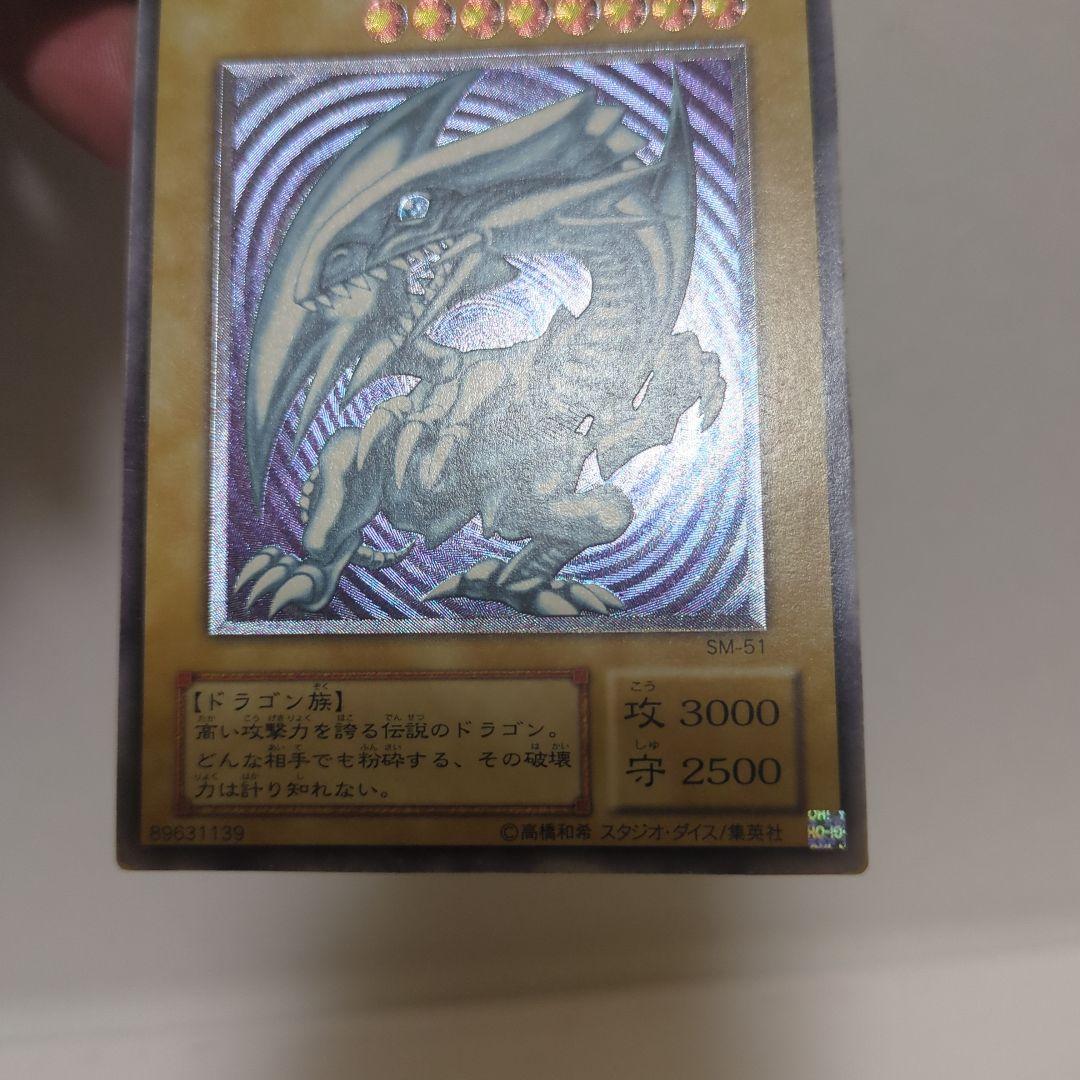 Blue-Eyes White Dragon Ultra Rare card collectible with 3000 attack, 2500 defense, chipped top and back, clean blue body