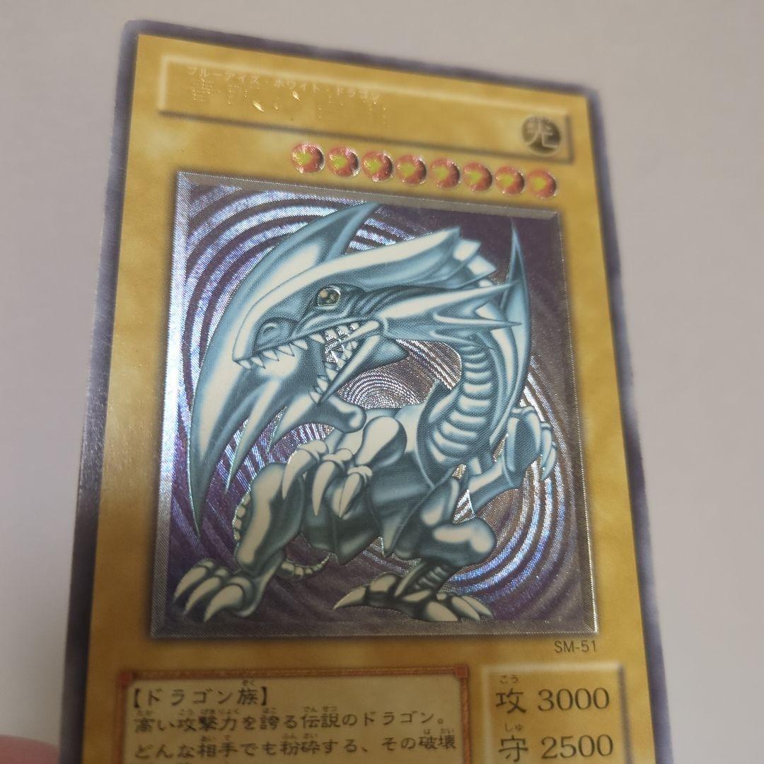 Blue-Eyes White Dragon Ultra Rare card collectible with 3000 attack, 2500 defense, chipped top and back, clean blue body