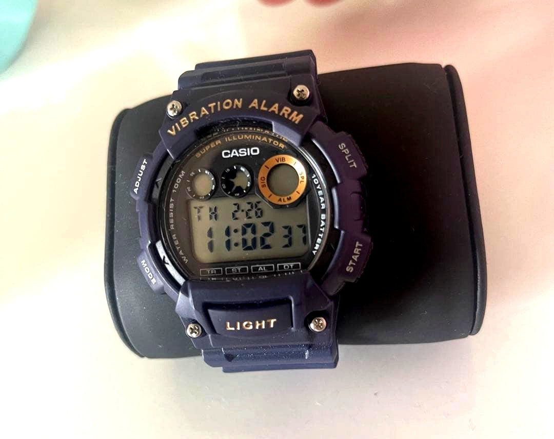 Casio navy digital watch with vibration alarm and backlight on a white background