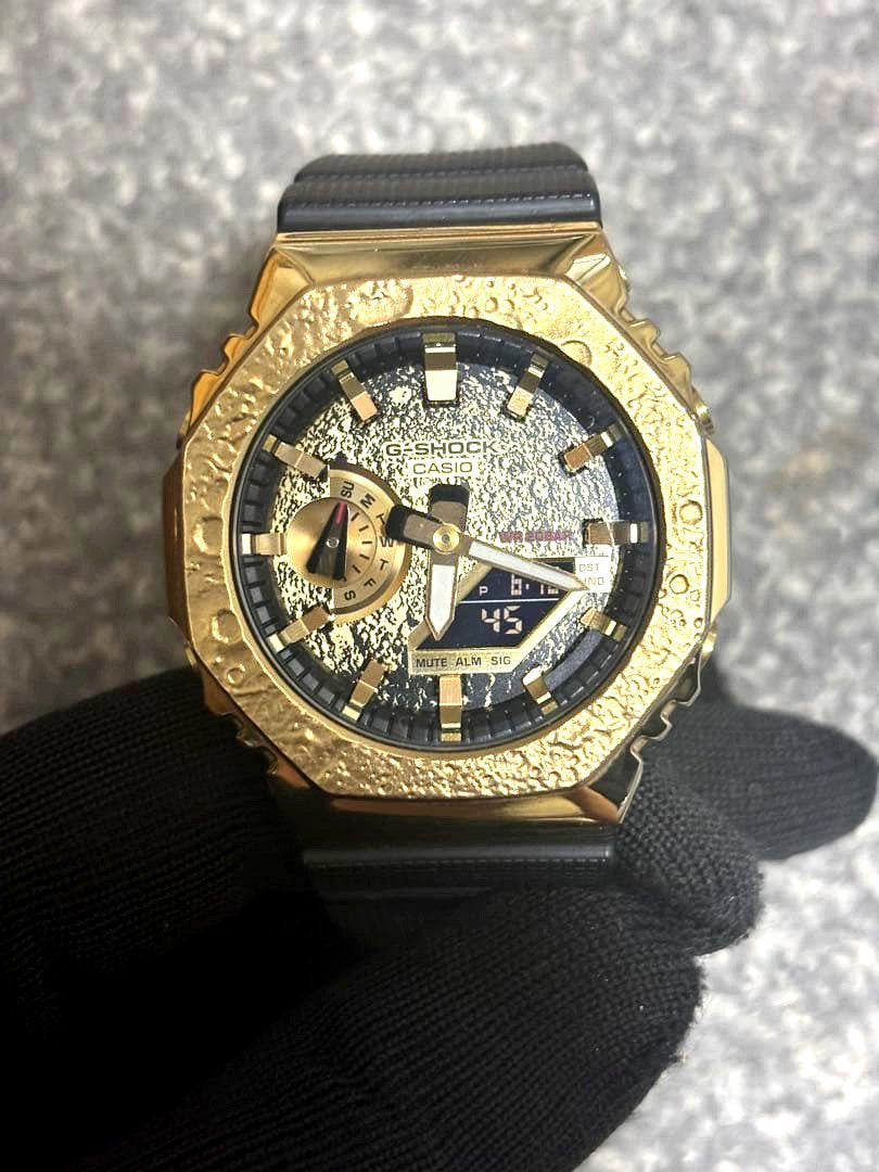 Casio G-Shock GM-2100MG-1AJR watch with gold metal bezel and moon theme design in excellent condition