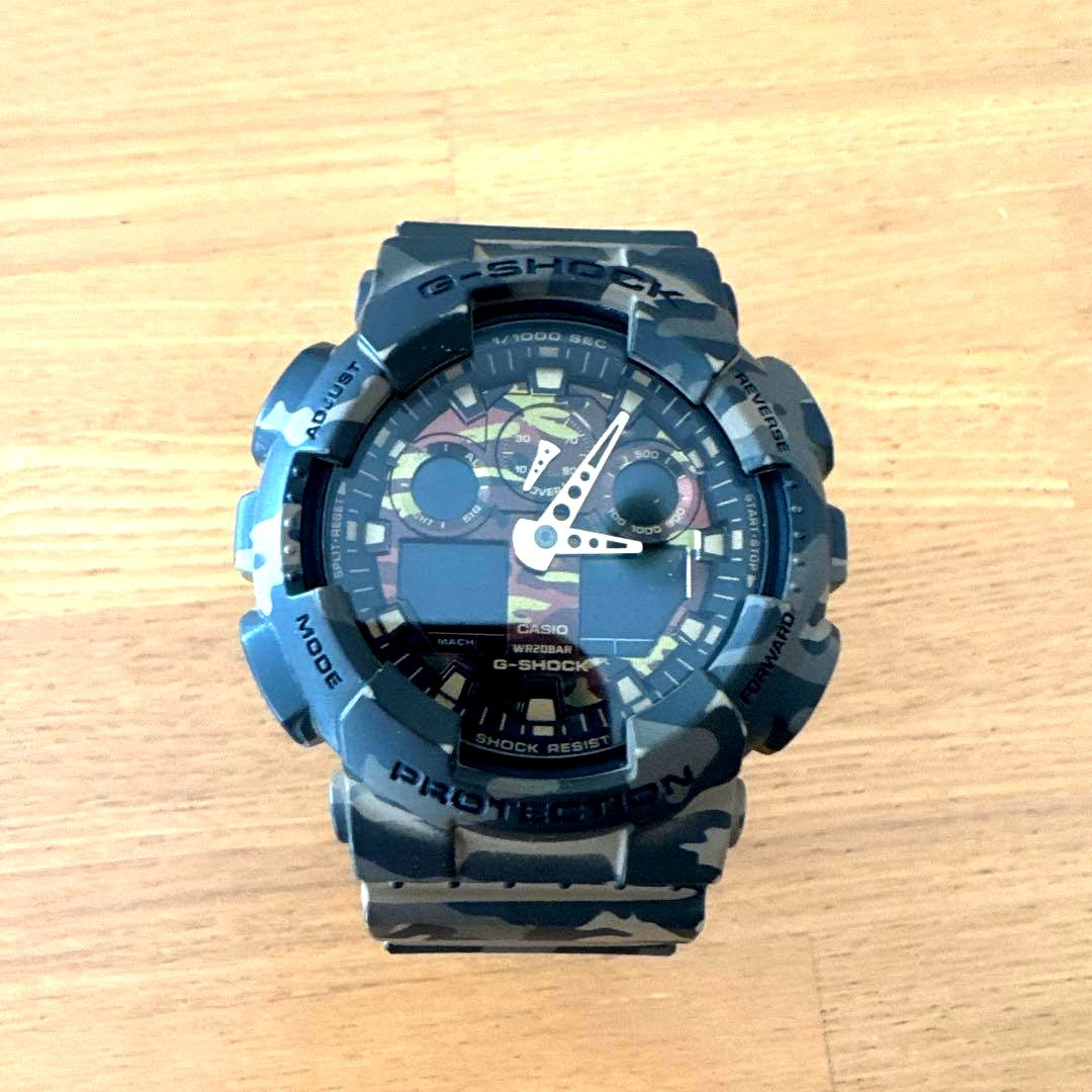 Casio G-Shock GA-100CM-5A camouflage digital analog watch showing time on resin band