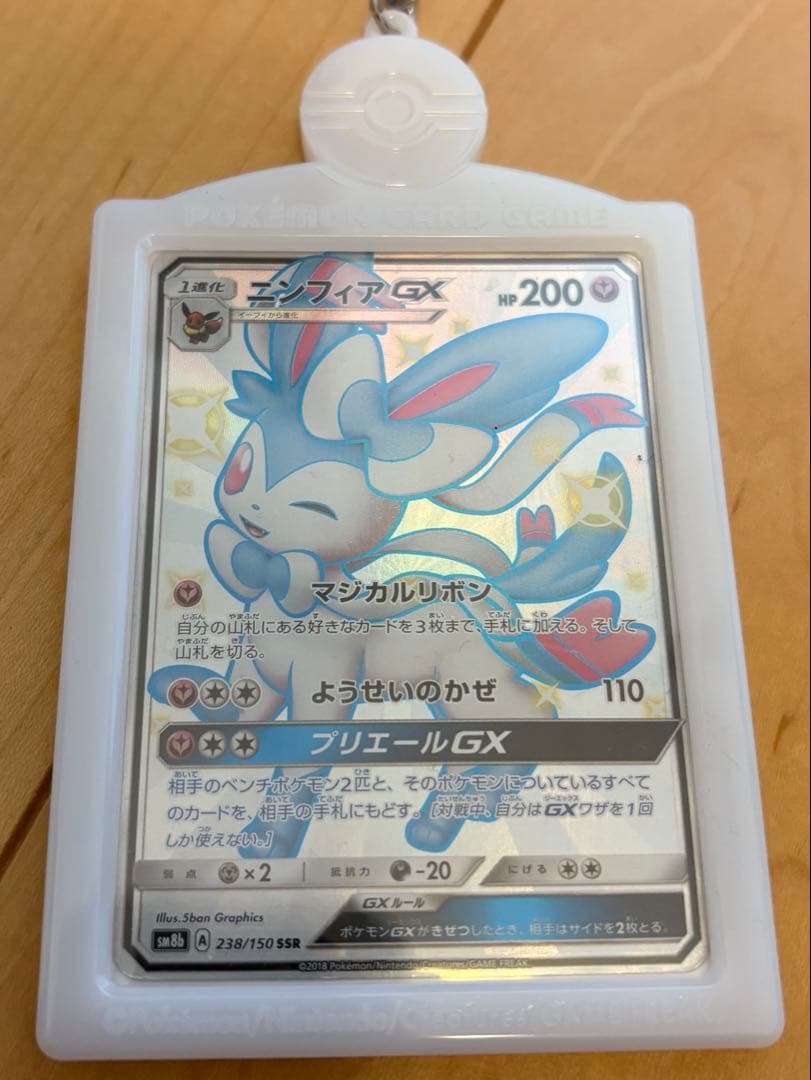 Niufia GX SSR Pokemon card in official sleeve with keychain holder, showing some scratches and folded packaging