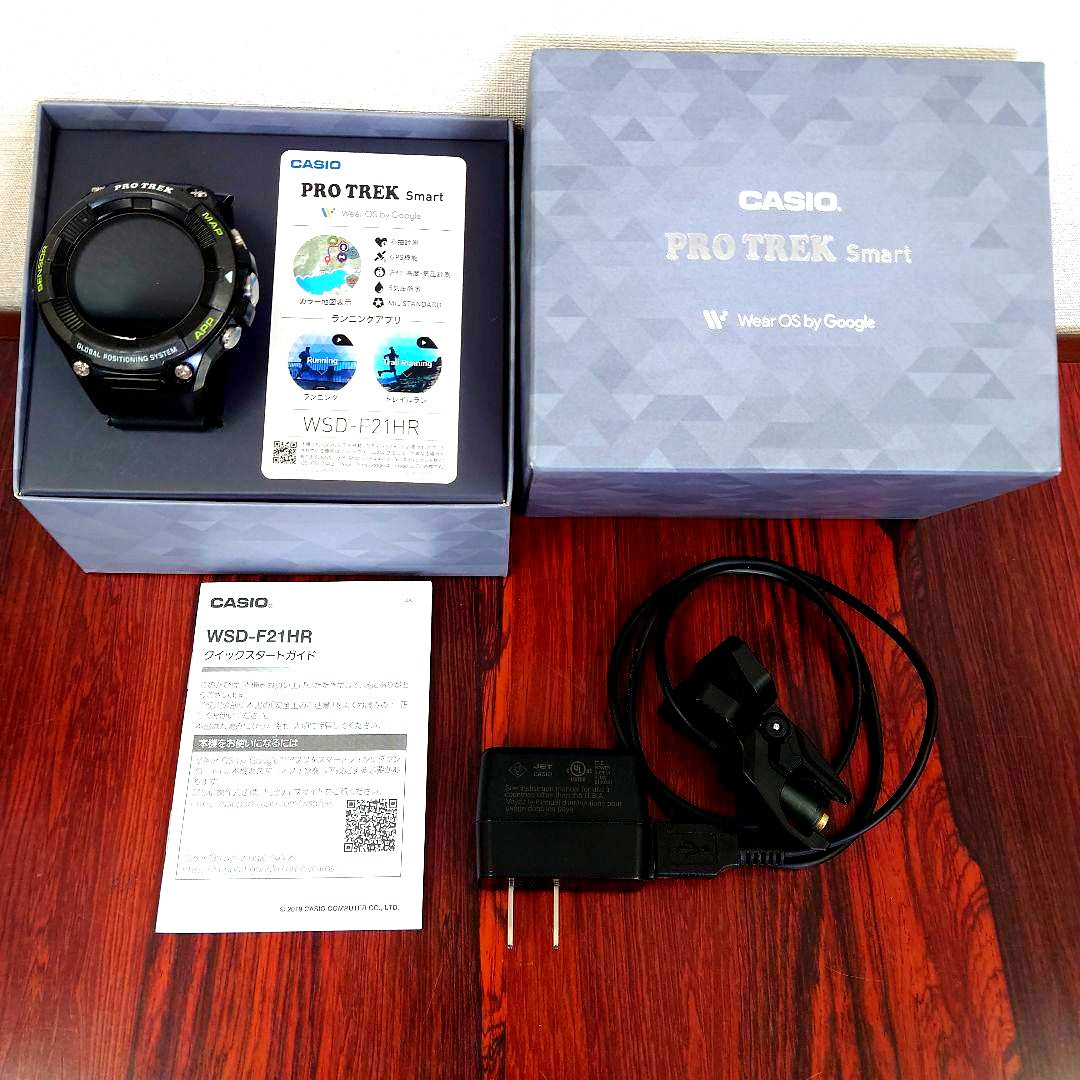 Casio WSD-F21HR smart watch with GPS and sensors shown with charger and manual